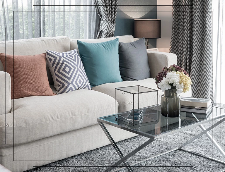 Kolorowe poduszki na jasnej kanapie w salonie
